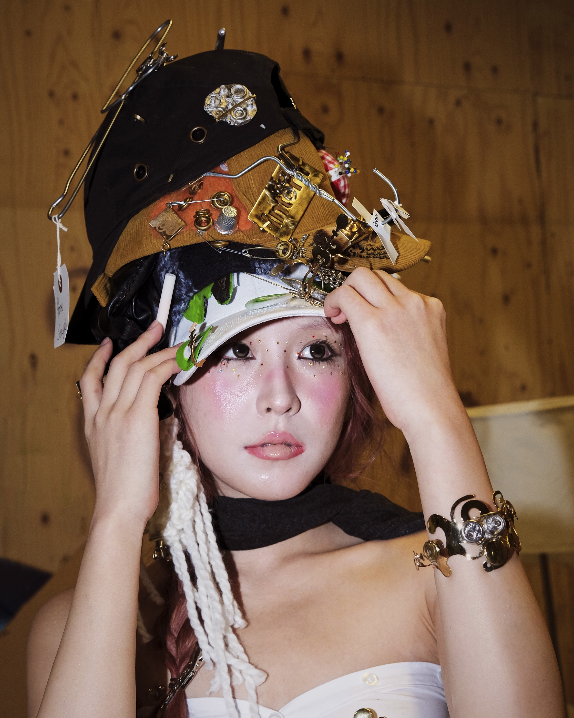 Adjusting headpiece backstage at Central Saint Martins